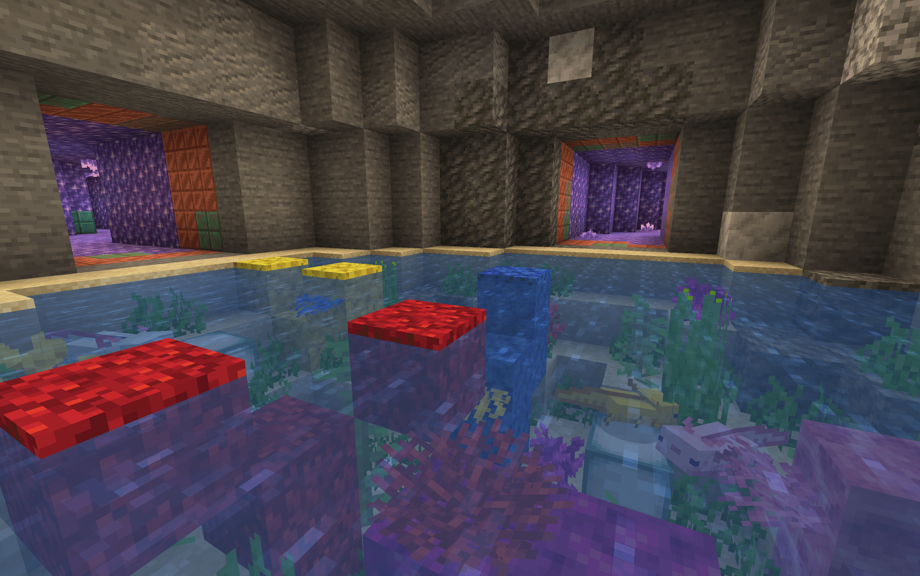 A chamber filled with water, coral, and axolotls.